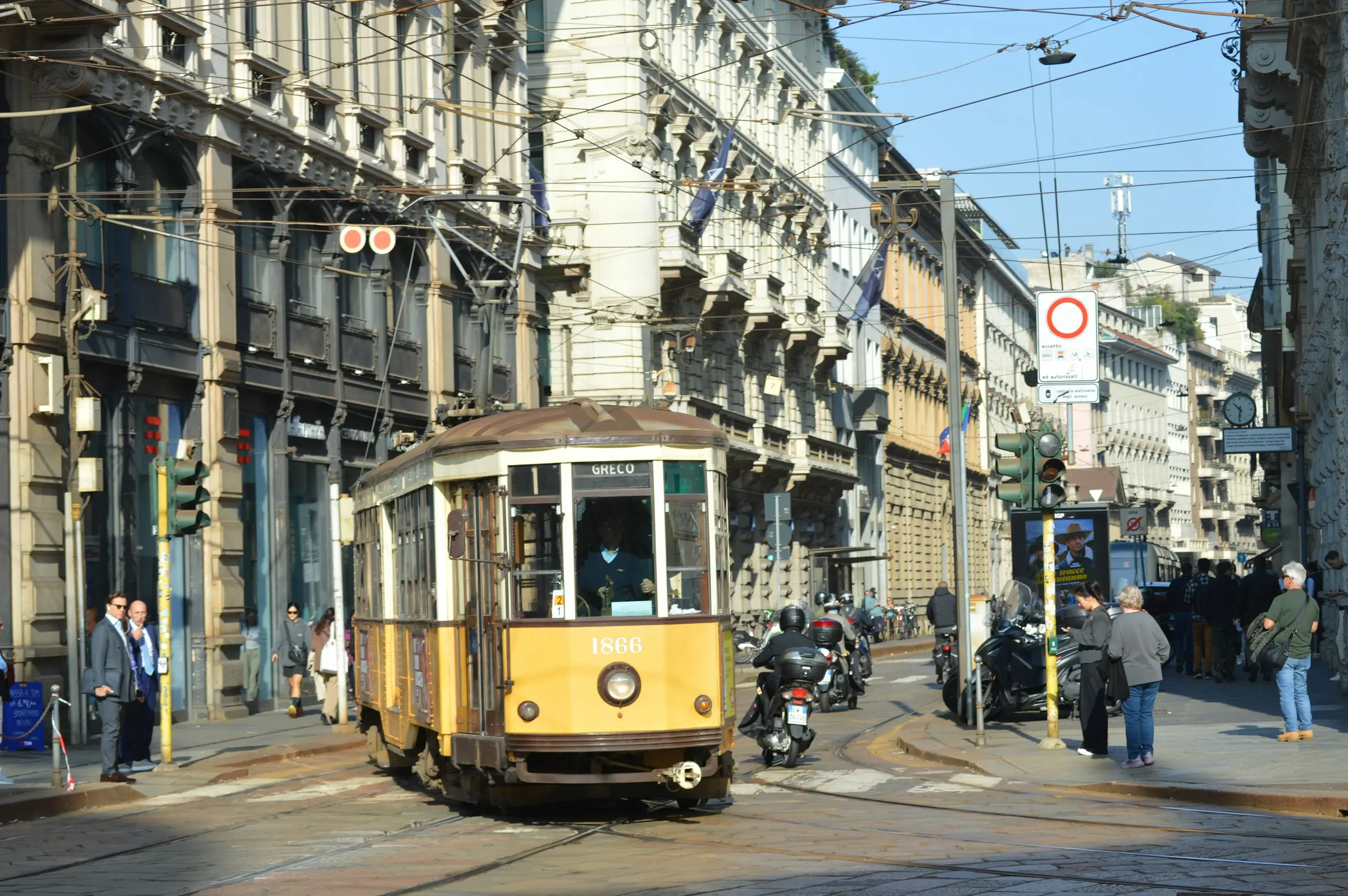 Tram storico giallo lungo una via del centro di Milano, tra palazzi d’epoca
