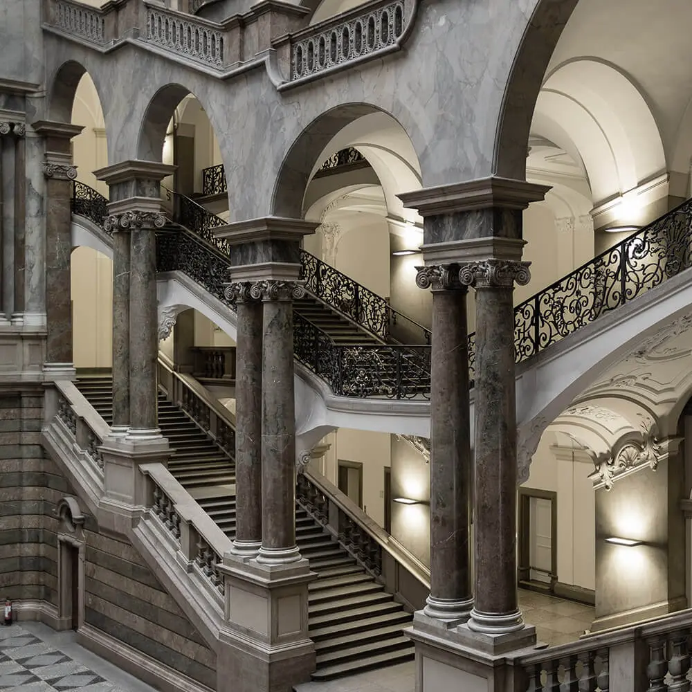 Scalone con colonne e balaustre in ferro battuto di un palazzo storico